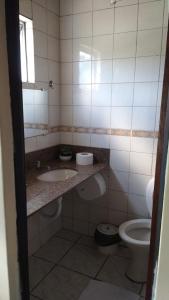 bagno con 2 lavandini e servizi igienici di HOTEL TROPICAL a Curitiba