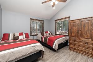 a bedroom with two beds and a dresser and two windows at Eagle Nest in Valemount