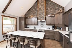 a kitchen with wooden cabinets and a stone wall at Eagle Nest in Valemount
