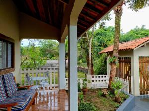 un porche de una casa con una valla en LARA'S HOUSE, en São Sebastião