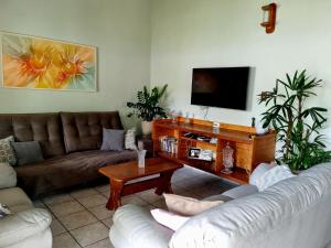 a living room with couches and a flat screen tv at LARA'S HOUSE in São Sebastião