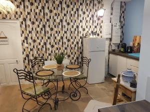 eine Küche mit einem Tisch und Stühlen sowie einem Kühlschrank in der Unterkunft Fenêtre sur cour du Docteur Privey in Tournus