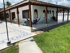 Biały dom z werandą z fioletowym krzesłem w obiekcie La Quinta A w mieście Carmen de Apicalá
