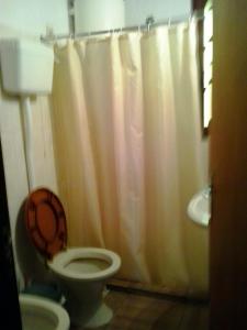 a bathroom with a toilet and a shower curtain at ANAHATA in Barra del Chuy