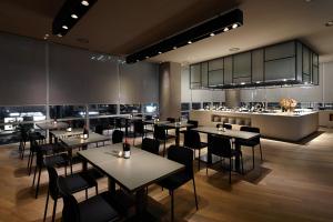 a restaurant with tables and chairs and a kitchen at Shilla Stay Ulsan in Ulsan