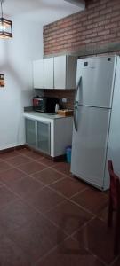 uma cozinha com um frigorífico branco e piso em azulejo em El Refugio em San Fernando del Valle de Catamarca