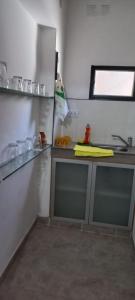 cocina con fregadero y nevera en El Refugio en San Fernando del Valle de Catamarca