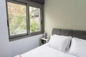 a bedroom with a white bed and a window at Ermis apartment in Athens +4 photos