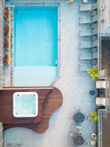einen Blick über einen Pool mit einer Bank daneben in der Unterkunft Del Rey Quality Hotel in Foz do Iguaçu