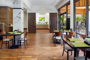 a restaurant with wooden floors and tables and chairs at Holiday Inn and Suites Phoenix Airport North, an IHG Hotel in Phoenix