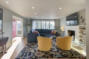 uma sala de estar com um sofá azul e duas cadeiras amarelas em Luke's Landing em Westport