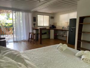 Una habitación con cocina y una cama con toallas. en Nahele Lodge, en Santa Teresa Beach