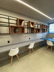Cette chambre dispose d'une table, de deux chaises et d'un bureau. dans l'établissement Edificio Liv P.Verde Apto 1014-Mandi Hospitalidade, à Maceió