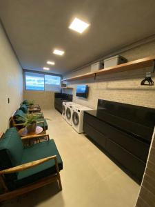 ein Wohnzimmer mit Sofas und eine Küche mit Waschmaschine in der Unterkunft Edificio Liv P.Verde Apto 1014-Mandi Hospitalidade in Maceió