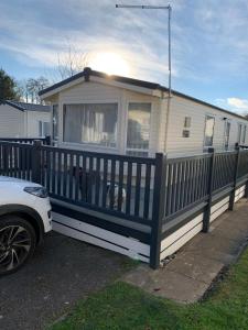 a mobile home with a fence and two dogs in it at Foxglove Fourteen in Saint Leonards