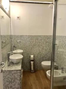 a bathroom with two sinks and a toilet and a shower at Loft -MM Piazza Bande Nere in Milan