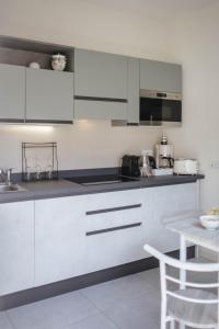 a kitchen with white cabinets and a table at Tra Lago Maggiore e lago d'Orta Appartamento ACQUA in Colazza