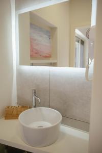 a bathroom with a white sink and a mirror at Tra Lago Maggiore e lago d'Orta Appartamento ACQUA in Colazza