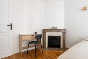 a bedroom with a desk and a chair next to a fireplace at The Square, Paris-Asnières, Private Apartment with Bedroom and Living Room in Asnières-sur-Seine