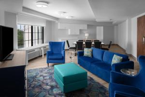 Hotel Indigo Charleston - Mount Pleasant, an IHG Hotel في تشارلستون: غرفة معيشة مع أريكة زرقاء وطاولة