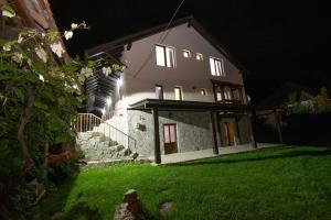 uma casa à noite com as luzes acesas em Casa de vacanță Edya em Petroşani