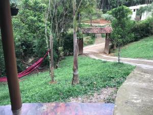 a garden with a hammock in the grass at Chalé da Flor in Visconde De Maua