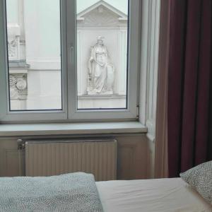a statue sitting in a window next to a bed at Large 4 room apartment in the center of Vienna in Vienna