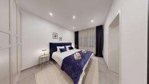 1 dormitorio con 1 cama grande con manta azul en STAY SMART Luxembourg Dudelange Center, en Dudelange