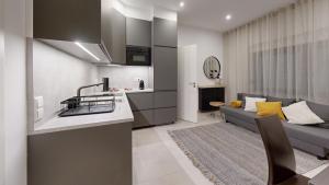 a kitchen and a living room with a couch at STAY SMART Luxembourg Dudelange Center in Dudelange
