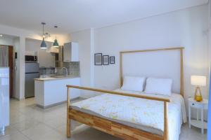 a bedroom with a bed and a kitchen at Seaside Apartment in Salamina