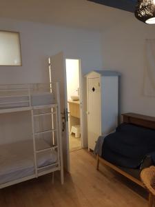 a bedroom with two bunk beds and a door to a bathroom at La suite du Docteur Privey in Tournus