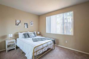 a bedroom with a bed and a large window at Modern 2BR-2BA Condo Pool, Gym & Parking Near Airport in Phoenix