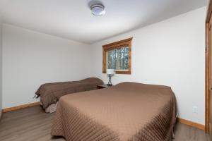 een slaapkamer met 2 bedden en een raam bij The Evergreen Cabin in Valemount