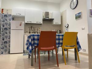a kitchen with two chairs and a table and a refrigerator at La perla del mare in Trapani