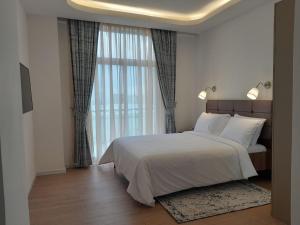 a bedroom with a bed and a large window at Zemilo Hotel Apartment in Addis Ababa