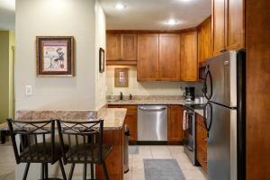 a kitchen with wooden cabinets and a stainless steel refrigerator at Fantastic Steamboat Location With Amazing Views in Steamboat Springs