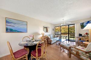 a living room with a table and chairs at Kauai Banyan Harbor B24 condo in Lihue