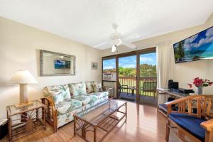 uma sala de estar com um sofá e uma mesa em Kauai Banyan Harbor B24 condo em Lihue