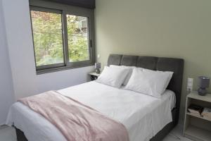 a bedroom with a large white bed with a window at Ermis apartment in Athens