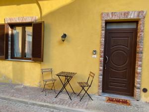 dwa krzesła i stół przed drzwiami w obiekcie B&B L'Antico Portone w mieście Caselle Torinese