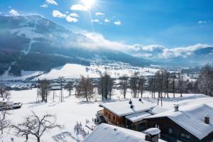 un lodge de ski dans la neige avec une montagne dans l'établissement Alpenchalet zurHinterochsenweide SKI IN & SKI OUT, à Brixen im Thale