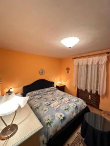 um quarto com uma cama e uma mesa com um candeeiro em Il Regno Dei Vacanzieri em Pescocostanzo