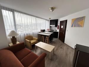 sala de estar con sofá, mesa y cocina en Stanford Suites Hotel, en Quito
