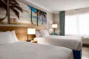 a hotel room with two beds and a window at Days Inn by Wyndham Miami Airport North in Miami