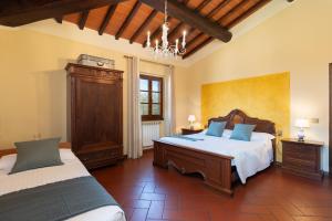 a large bedroom with two beds and a chandelier at Agriturismo Bellosguardo in Reggello