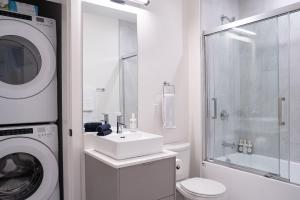 a white bathroom with a washing machine and a sink at Hygge Haus by Revelstoke Vacations in Revelstoke +29 photos