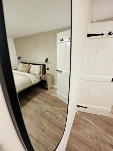 a mirror reflection of a bedroom with a bed at The Nook Cottage, Parkgate, Wirral in Parkgate