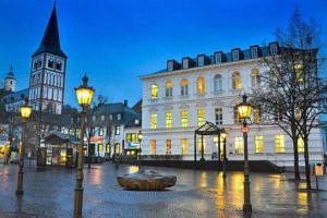 a building with a sculpture in the middle of a street at night at 3-Zimmer mitten in Siegburg in Siegburg