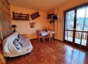 a living room with a couch and a table and a window at Amy House in San Giacomo
