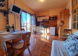 a living room with a table and a kitchen at Amy House in San Giacomo